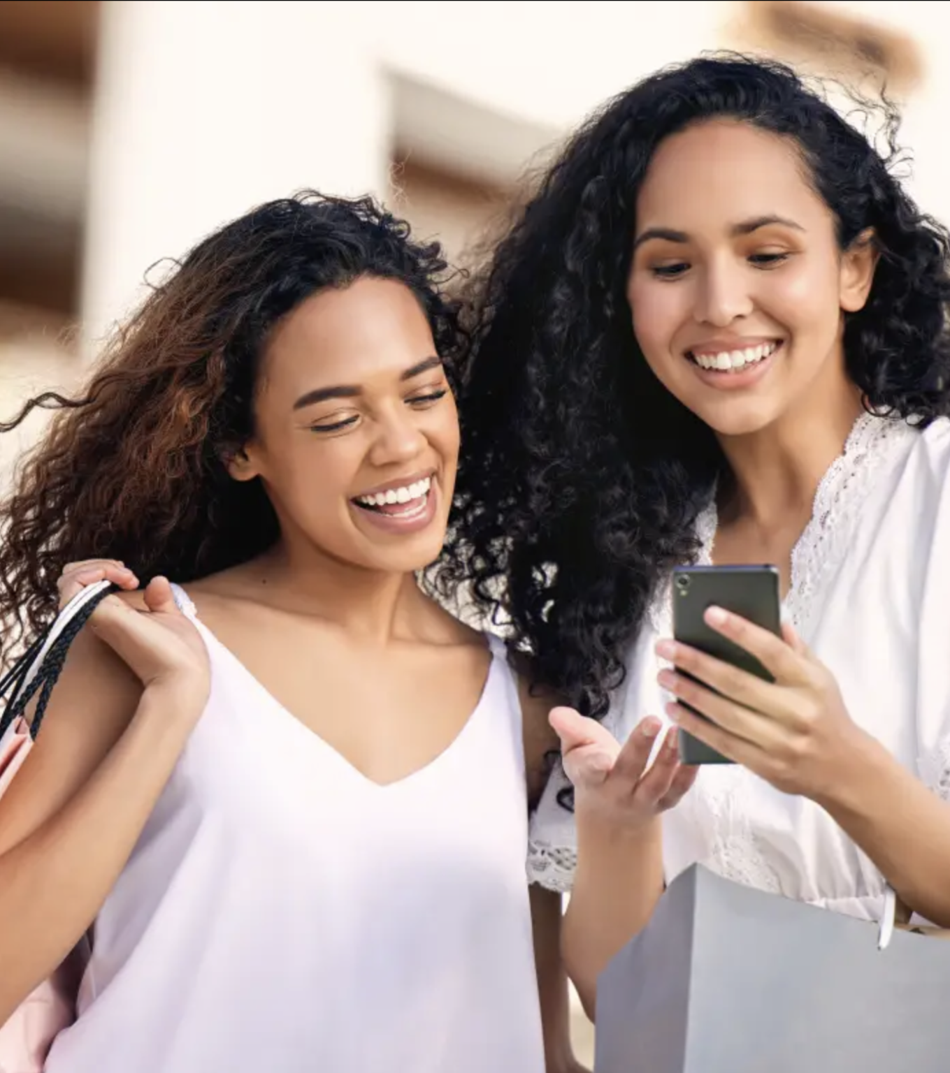 Two women smiling while looking at a phone