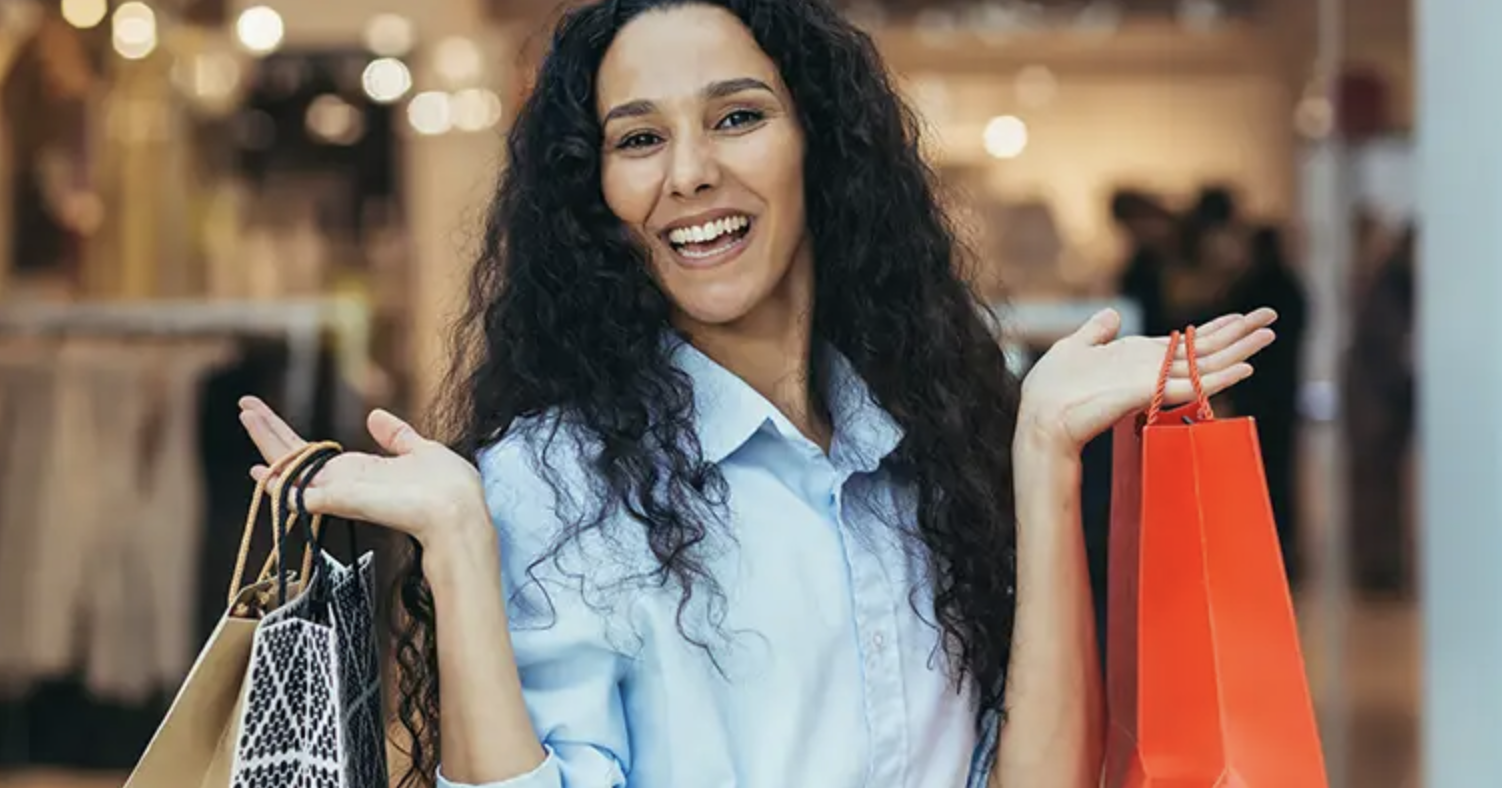 Woman smiling while holding shopping bags